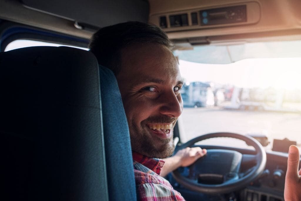 cdl driver behind the wheel showing thumbs up