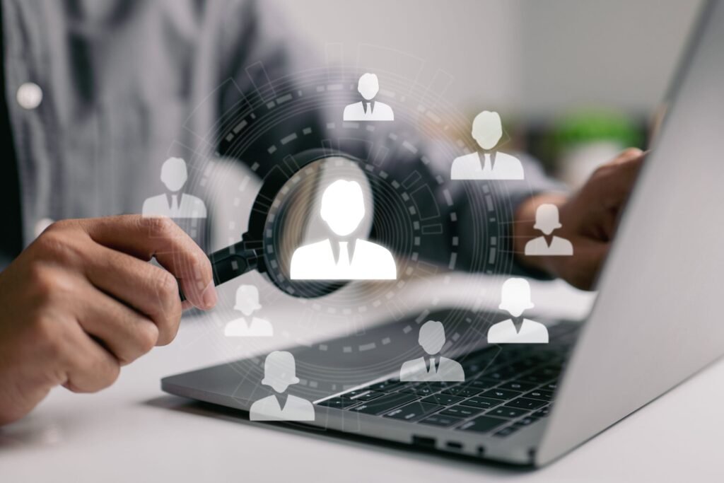 man with magnifying glass looking at laptop